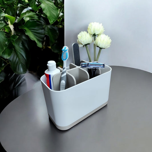 FlexiBox modularer Badezimmer-Organizer in Soft White mit fünf Fächern für Zahnbürsten, Zahnpasta und Rasierer auf einem Beistelltisch neben einer Pflanze.