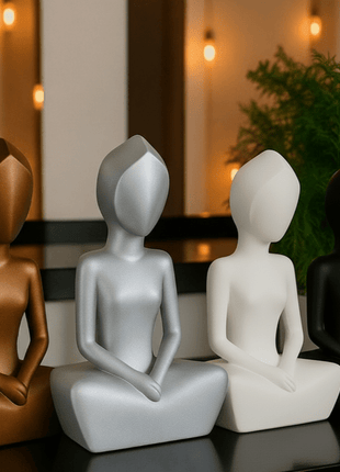 Anmutige Eleganz: Die feminine Frauenskulptur - Print HomeAnmutige Eleganz: Die feminine Frauenskulptur8867679Print HomeVier moderne Meditationsfiguren in den Farben Kupfer, Silber, Weiß und Schwarz als Set auf einer dunklen Oberfläche vor Pflanzen und warmen Lichtern.